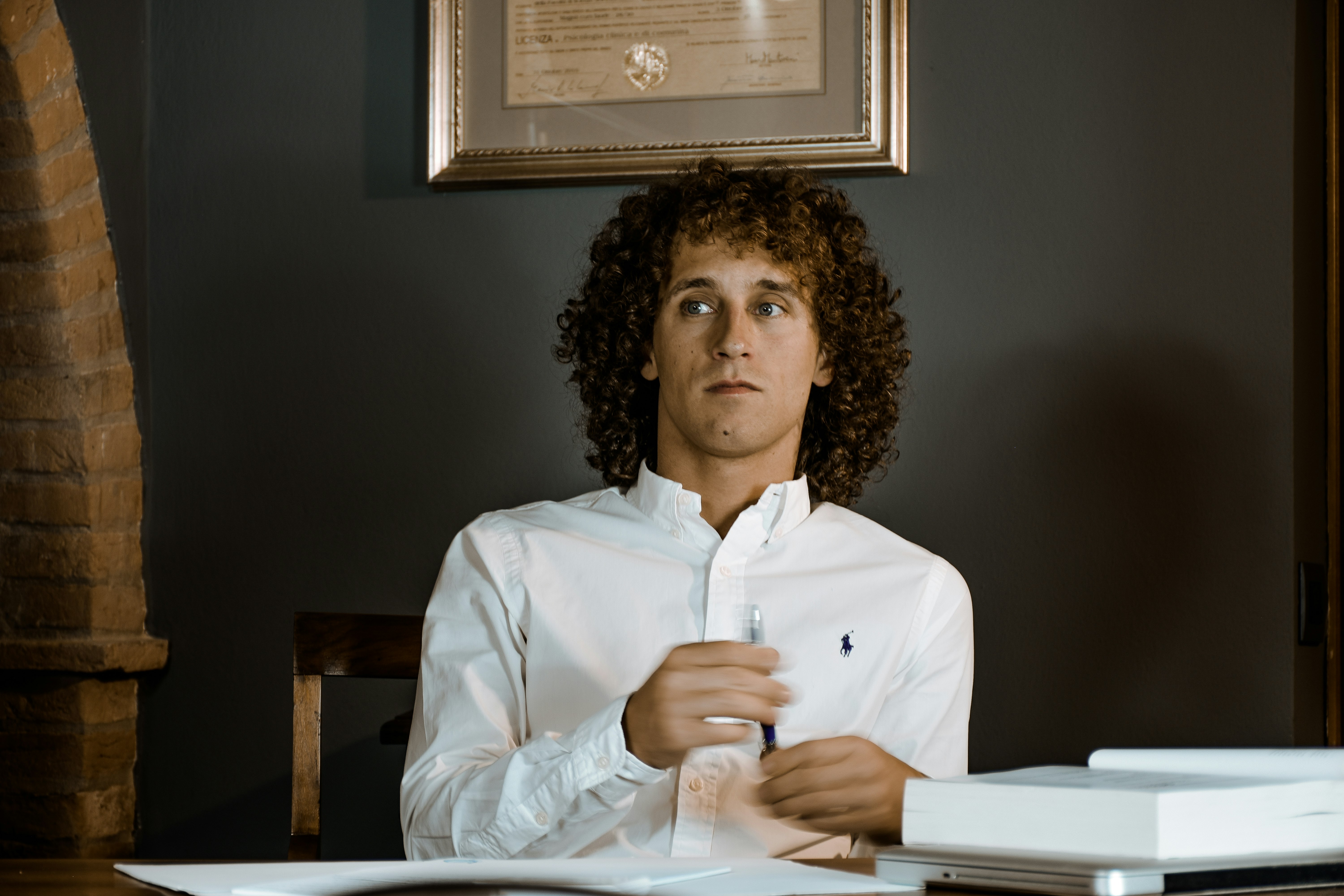 woman in white dress shirt sitting on brown wooden chair